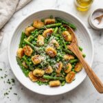 Crispy Gnocchi with Asparagus and Peas Recipe - Crispy Gnocchi with Asparagus and Peas Recipe served in a white bowl overhead view